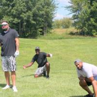six alumni posing on the golf course